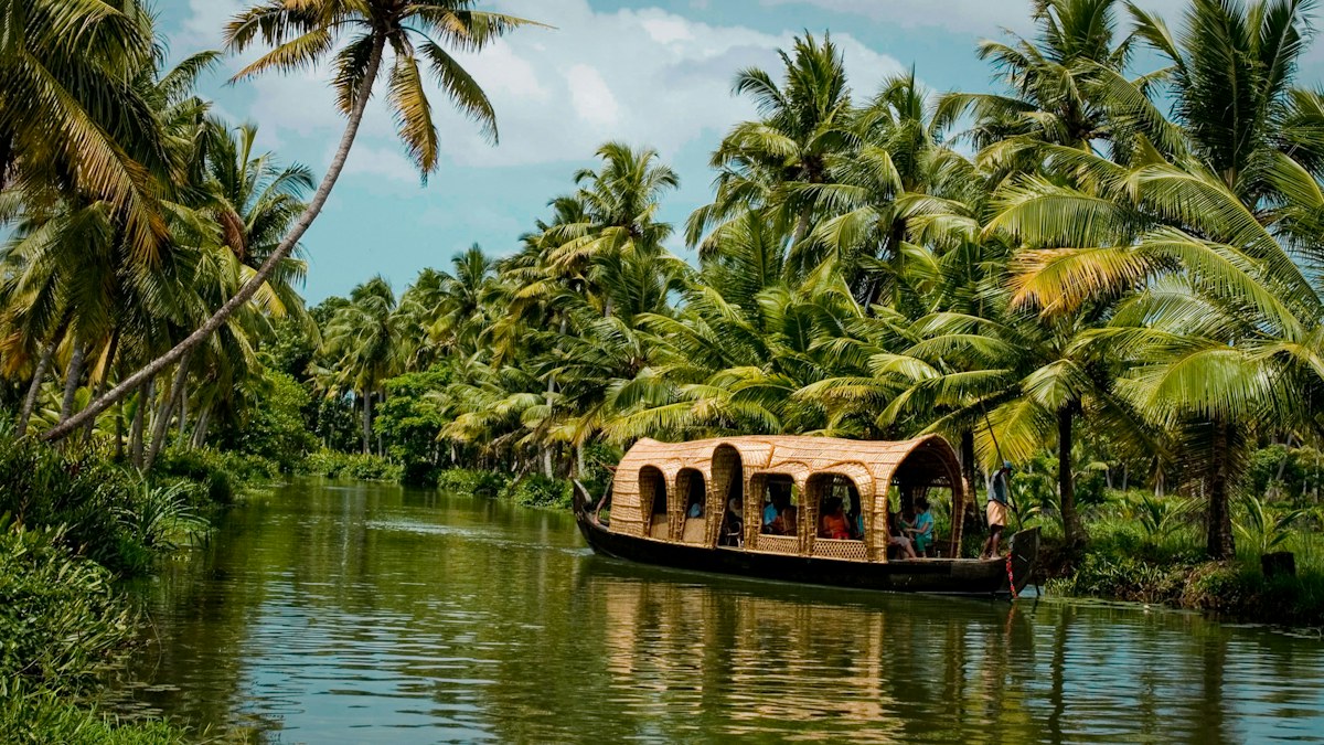 Traditional houseboat among Kerala backwaters and palms